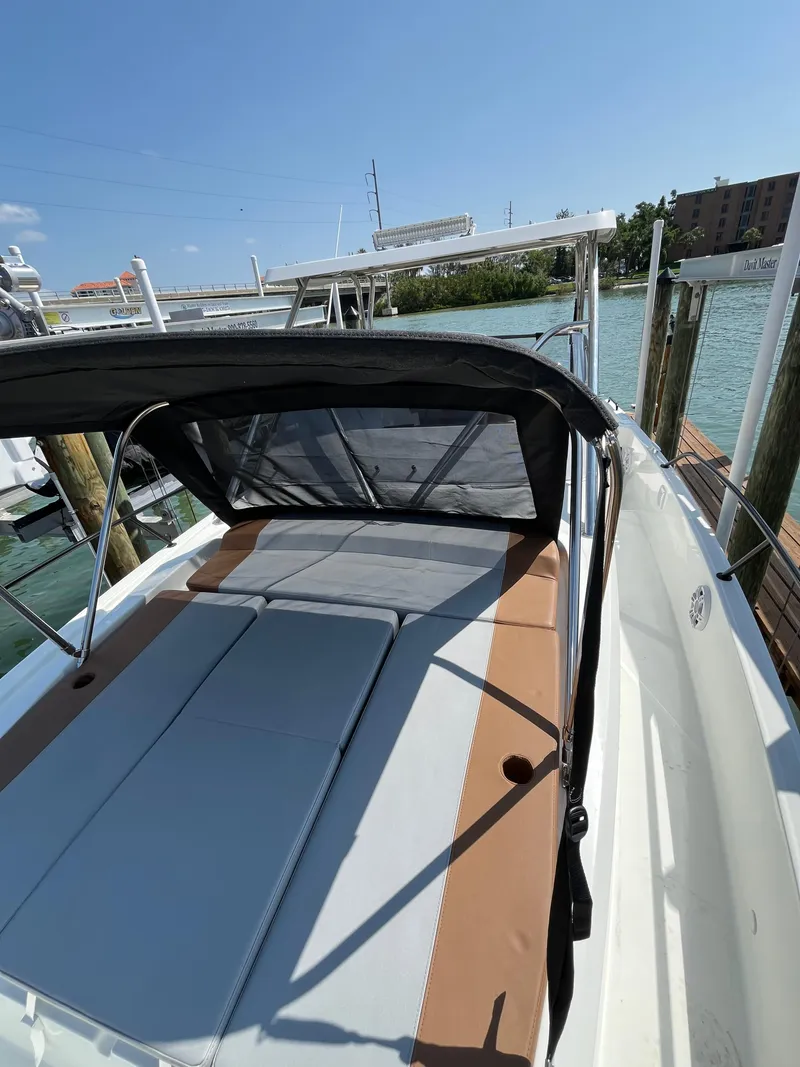 Slide: The Image of 2024 Beneteau 29' Flyer 9 SUNdeck boat docked by the water. - 14