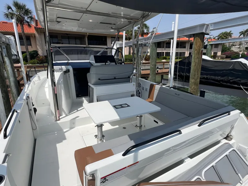 Slide: The Image of 2024 Beneteau 29' Flyer 9 SUNdeck boat with spacious seating and table, docked at marina. - 18
