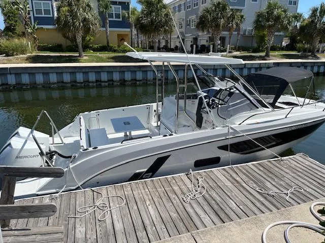 Slide: The Image of 2024 Beneteau 29' Flyer 9 SUNdeck boat docked by waterfront homes. - 2