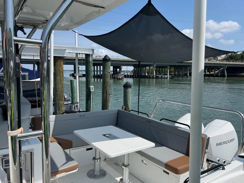 Slide: The Image of 2024 Beneteau 29' Flyer 9 SUNdeck with seating area, docked by a bridge. - 20