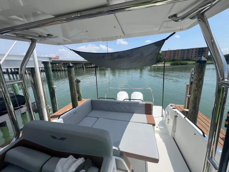 Slide: The Image of 2024 Beneteau 29' Flyer 9 SUNdeck, spacious deck with seating, docked by calm waters. - 21