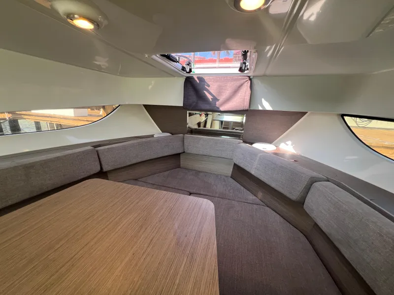 Slide: The Image of 2024 Beneteau Flyer 9 SUNdeck interior with cozy seating and wooden table. - 25
