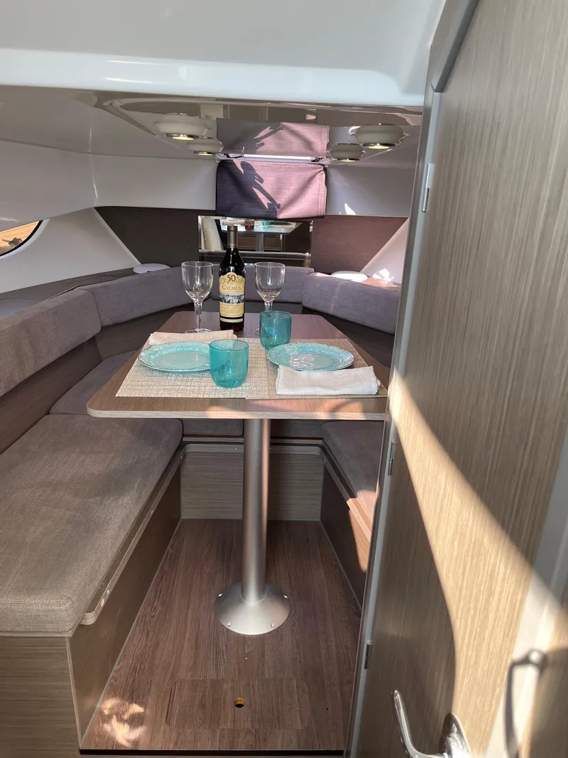 Slide: The Image of 2024 Beneteau 29' Flyer 9 SUNdeck interior with dining setup, featuring wine and tableware. - 26
