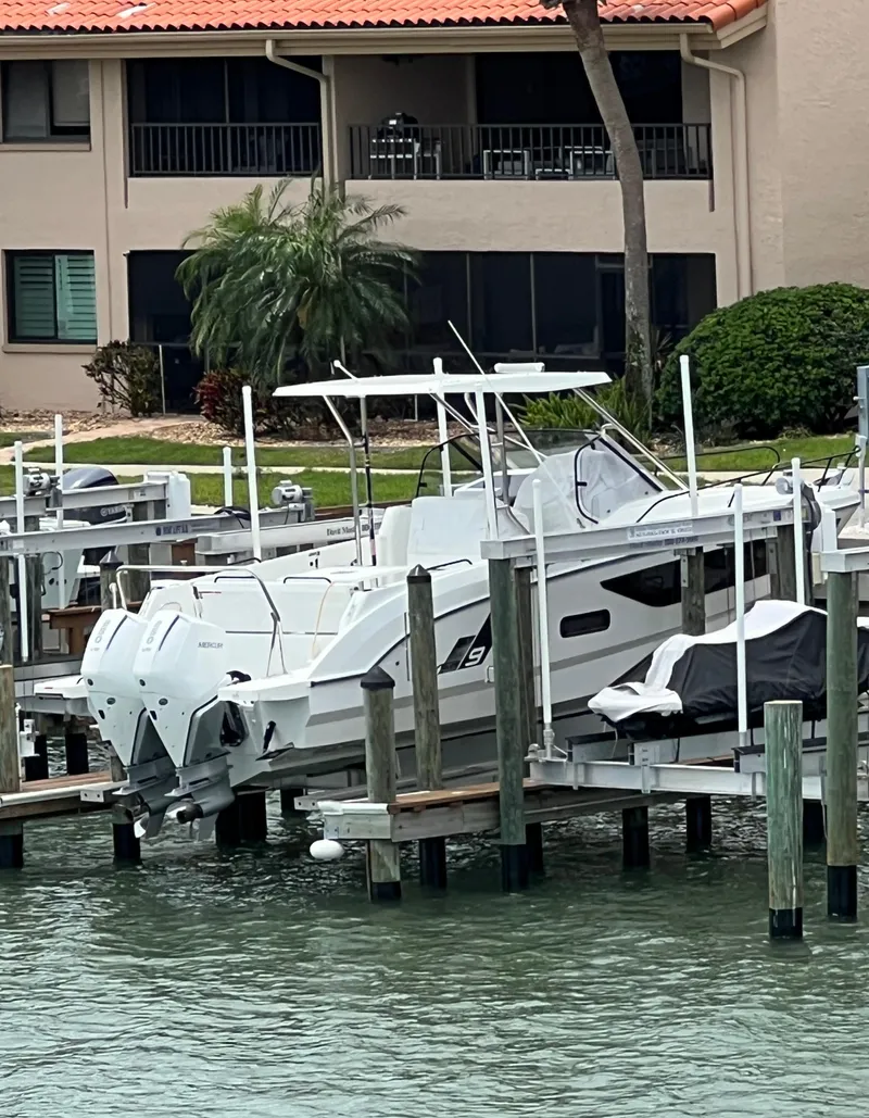 Slide: The Image of 2024 Beneteau 29' Flyer 9 SUNdeck docked near waterfront property. - 3