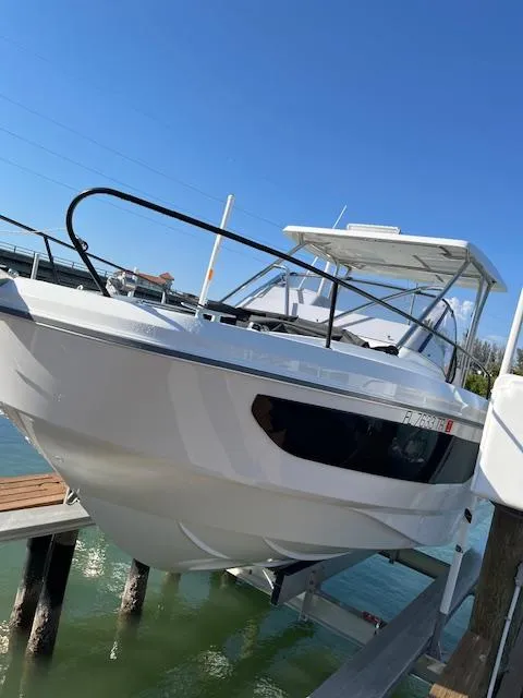 Slide: The Image of 2024 Beneteau 29' Flyer 9 SUNdeck boat docked under clear blue sky. - 4