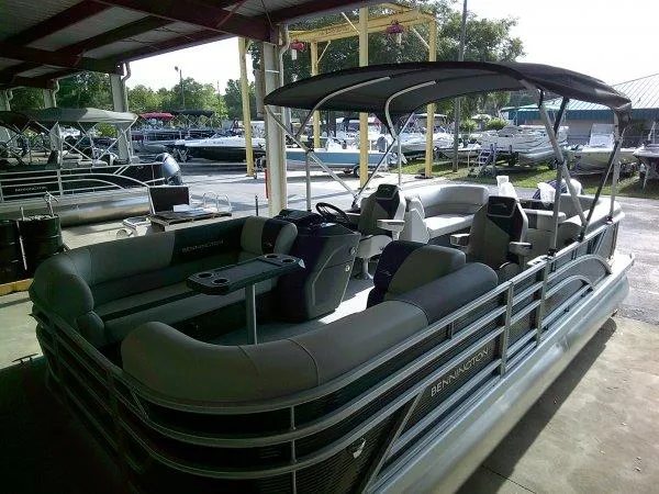 Slide: The Image of 2025 Bennington 22SSR pontoon boat with canopy, docked at marina. - 10
