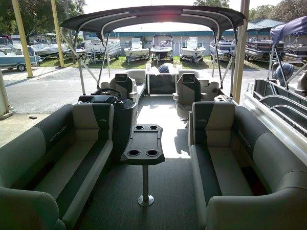 Slide: The Image of 2025 Bennington 22SSR pontoon boat interior with seating and table, docked at marina. - 11