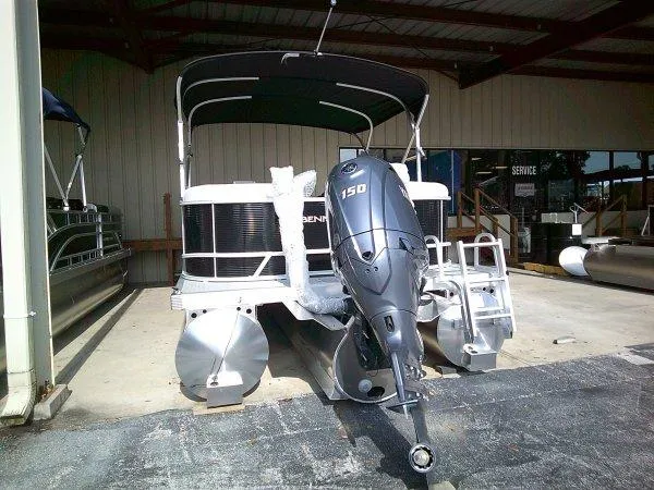 Slide: The Image of 2025 Bennington 22SSR pontoon boat with 150 HP engine in a showroom. - 15