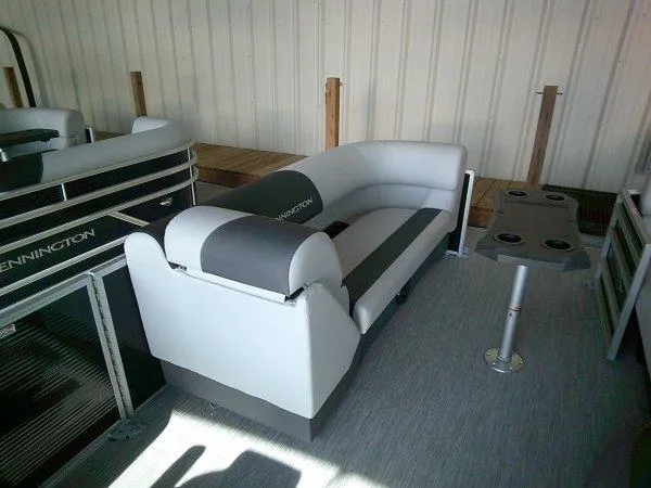 Slide: The Image of 2025 Bennington 22SSR pontoon boat interior with gray seating and cupholder table. - 3