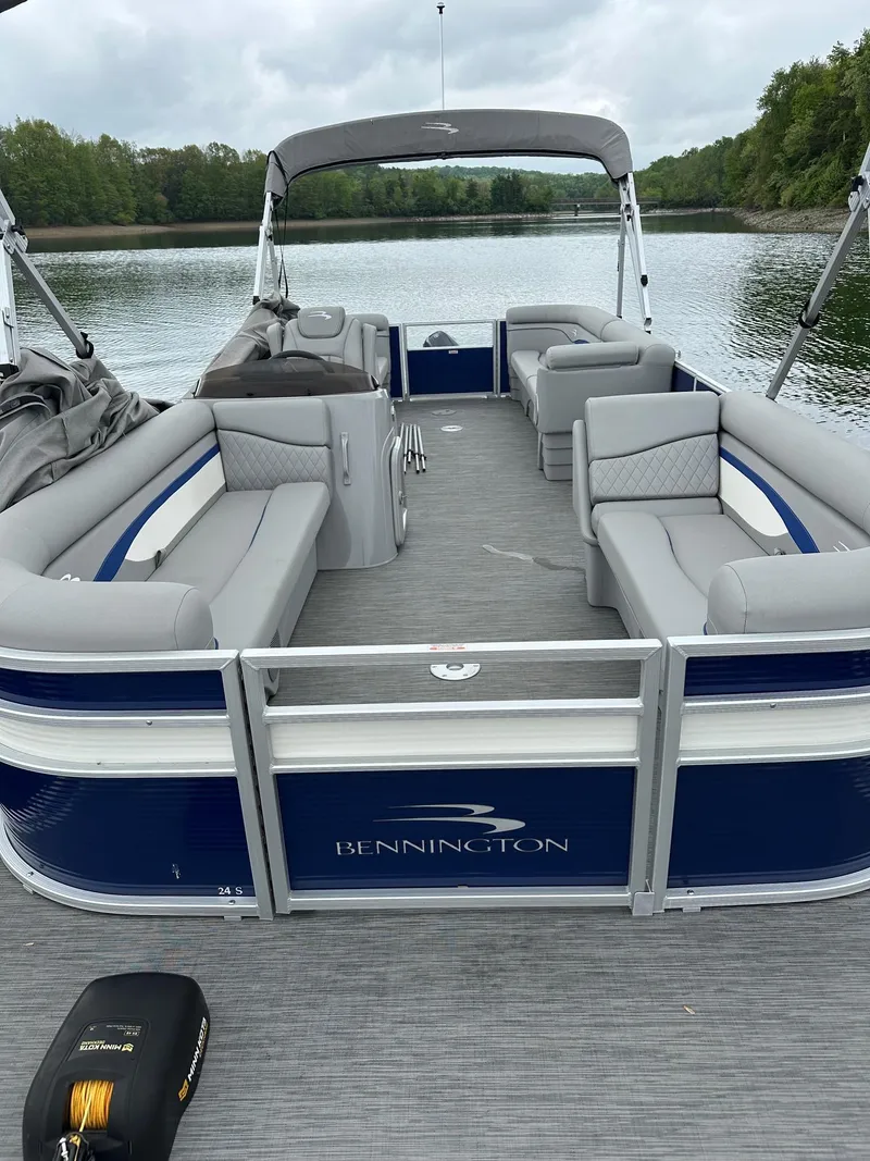 Slide: The Image of 2022 Bennington 24 SSR Quad Bench pontoon boat on a serene lake. - 3