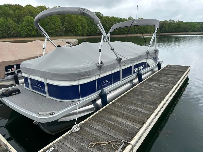 Slide: The Image of 2022 Bennington 24 SSR Quad Bench pontoon with Yamaha 25Hp, docked on a serene lake. - 5