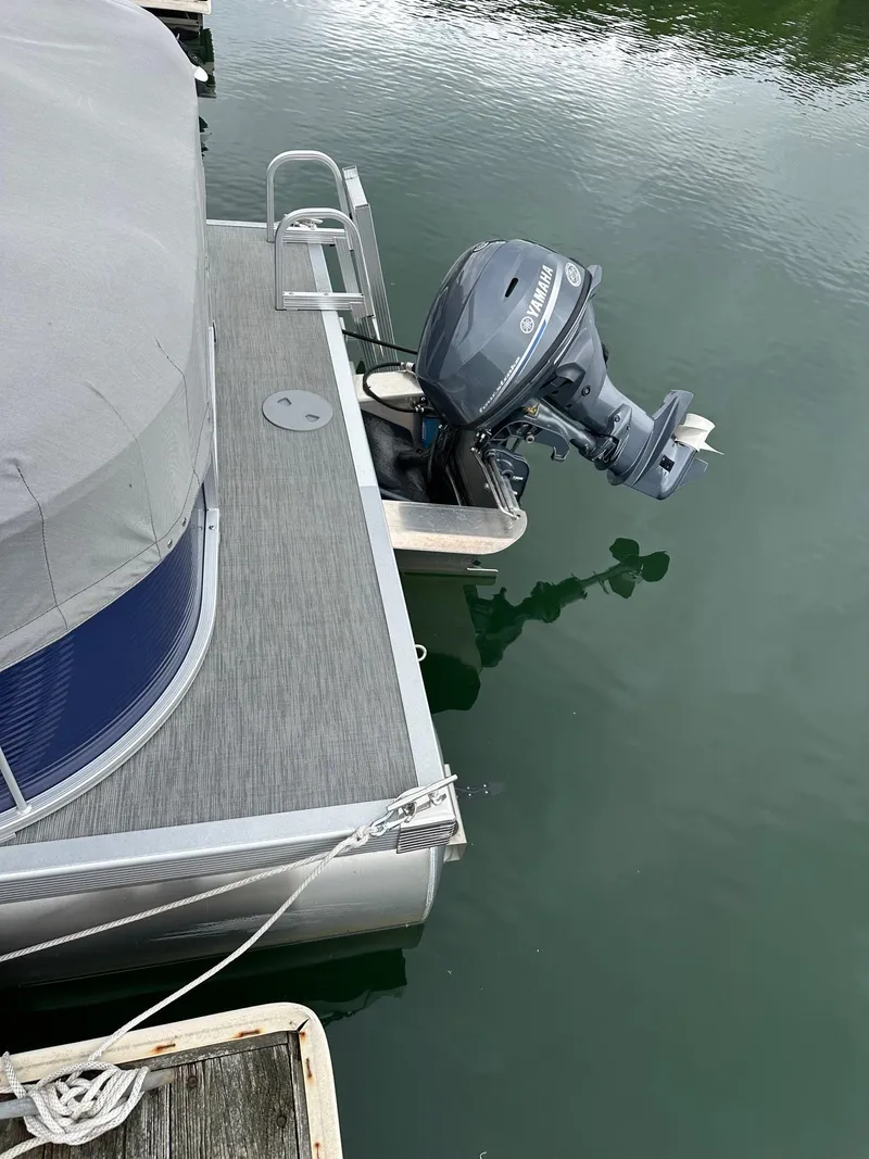 Slide: The Image of 2022 Bennington 24 SSR Quad Bench with Yamaha 25Hp engine docked on calm water. - 6