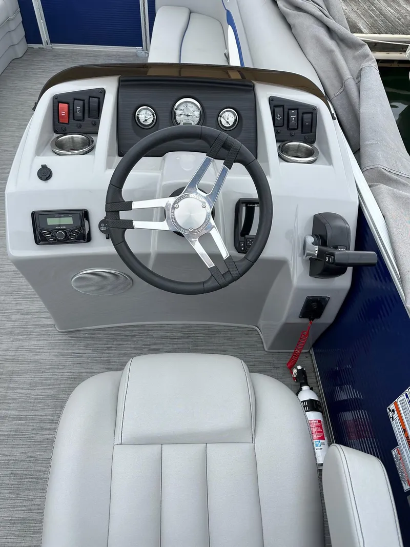 Slide: The Image of 2022 Bennington 24 SSR Quad Bench boat dashboard with steering wheel and controls. - 8