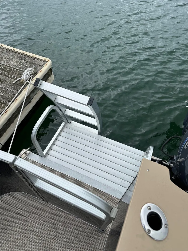 Slide: The Image of Aluminum ladder on 2018 Bennington 20 SSN pontoon boat docked by water. - 14