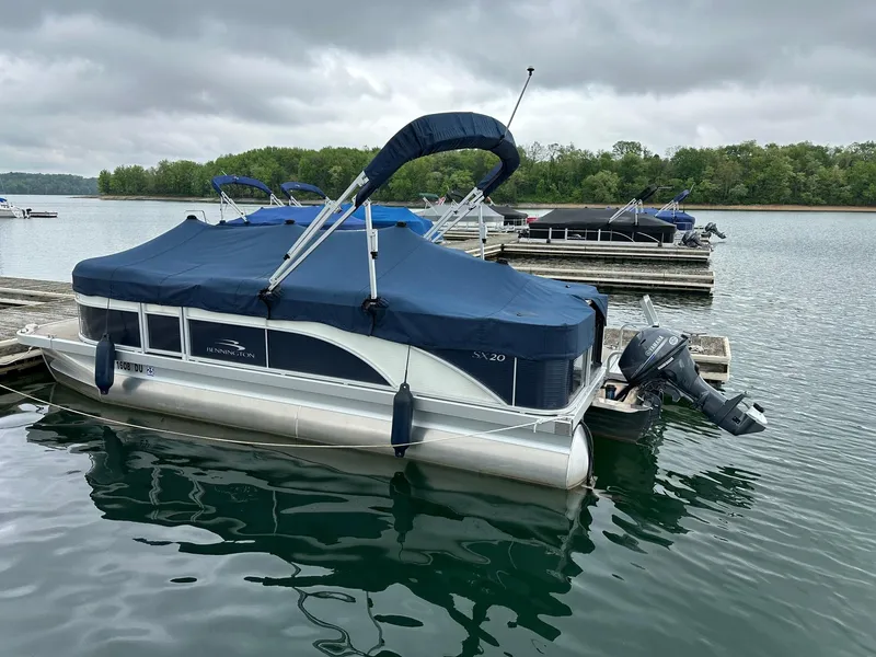 Slide: The Image of 2018 Bennington 20 SSN pontoon boat with Yamaha 25Hp engine docked on a lake. - 3