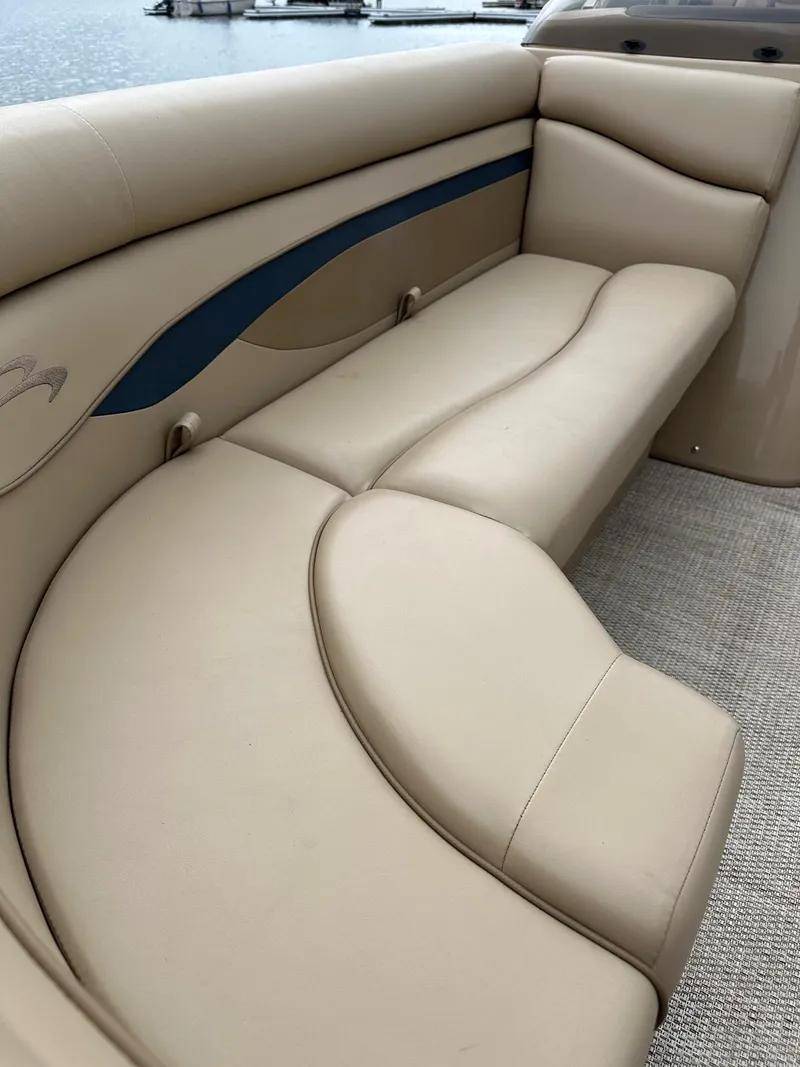 Slide: The Image of 2018 Bennington 20 SSN pontoon boat interior with beige seating and blue accents. - 6