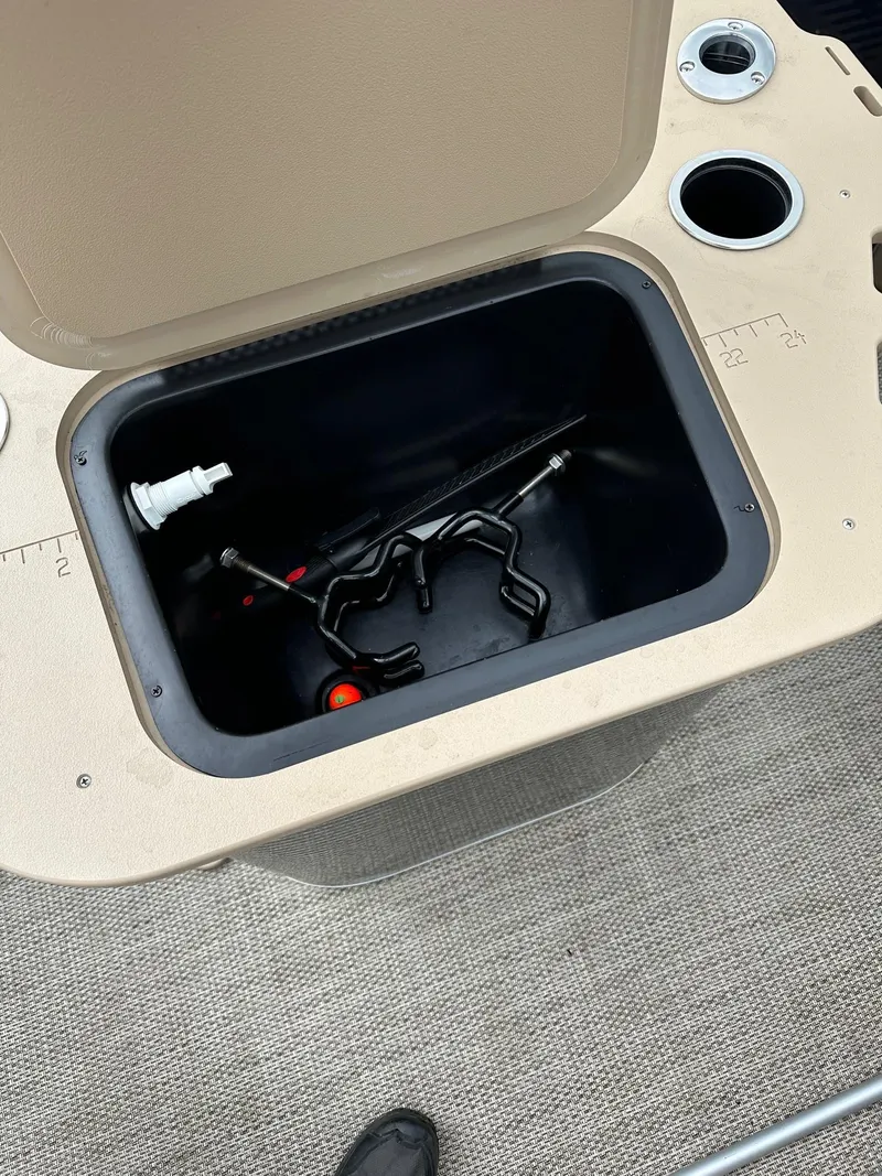 Slide: The Image of Open storage compartment on 2018 Bennington 20 SSN pontoon boat, showing various tools inside. - 9