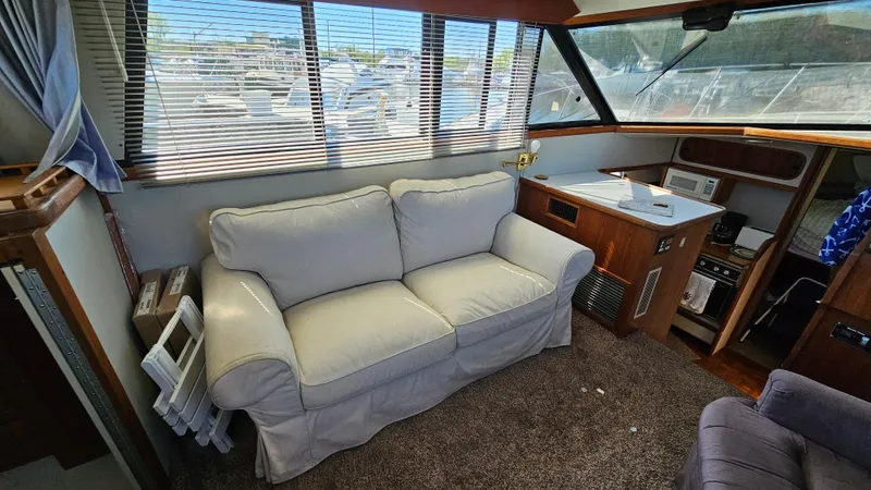 Slide: The Image of Interior of 1990 Carver 32 Aft Cabin with sofa and helm station. - 14