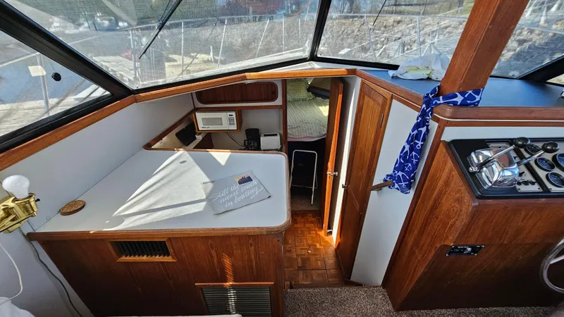 Slide: The Image of 1990 Carver 32 Aft Cabin interior with wood finish and navigation area. - 18