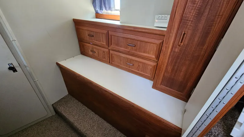 Slide: The Image of 1990 Carver 32 Aft Cabin interior with wooden drawers and carpeted steps. - 25