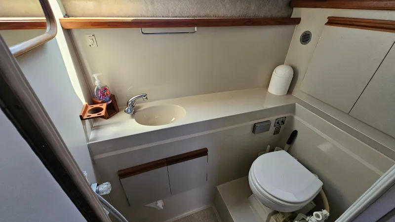 Slide: The Image of 1990 Carver 32 Aft Cabin bathroom with sink, toilet, and storage. - 27