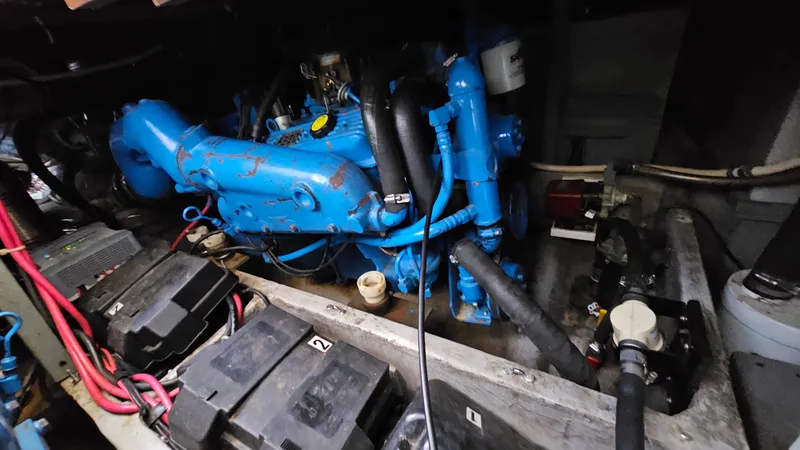Slide: The Image of Engine compartment of a 1990 Carver 32 Aft Cabin boat, featuring a blue engine. - 30