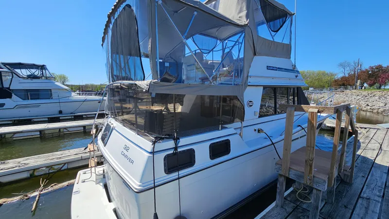 Slide: The Image of 1990 Carver 32 Aft Cabin boat docked at marina under clear blue sky. - 4