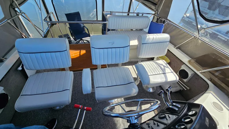 Slide: The Image of 1990 Carver 32 Aft Cabin interior with white seating and steering wheel. - 8