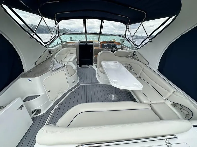 Slide: The Image of 2003 Wellcraft 3700 Martinique yacht interior with white seating and table, under a blue canopy. - 2