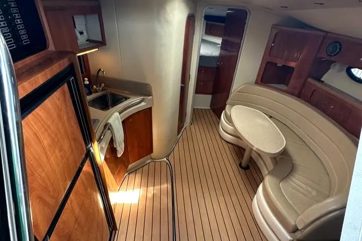 Slide: The Image of 2003 Wellcraft 3700 Martinique yacht interior with kitchen, seating area, and wooden flooring. - 5