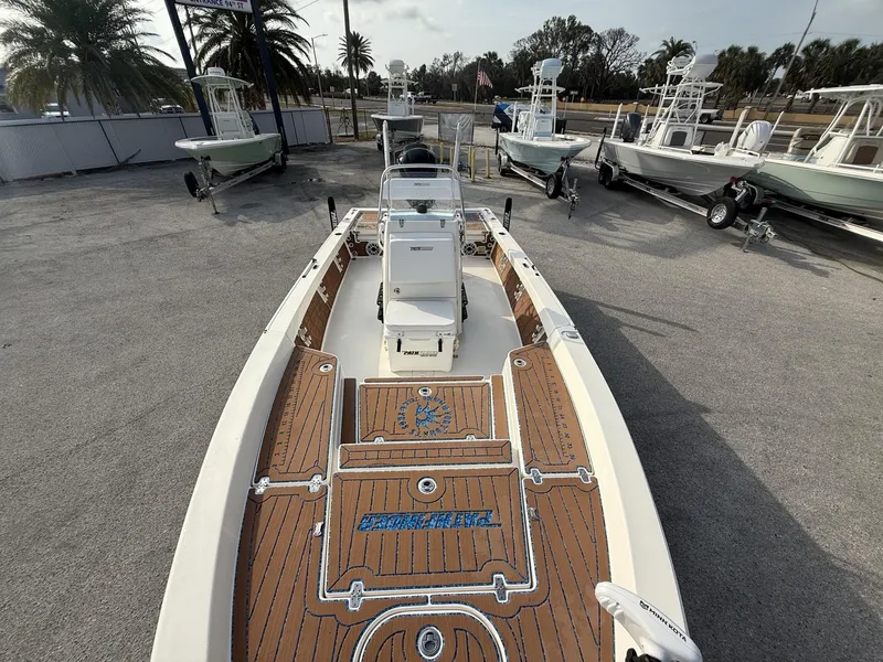 Slide: The Image of 2021 Pathfinder 2400 TRS boat with wooden deck, parked among other boats. - 12