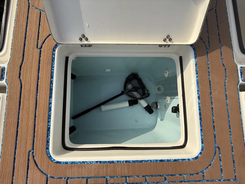 Slide: The Image of Open storage compartment on 2021 Pathfinder 2400 TRS boat with net and equipment. - 16