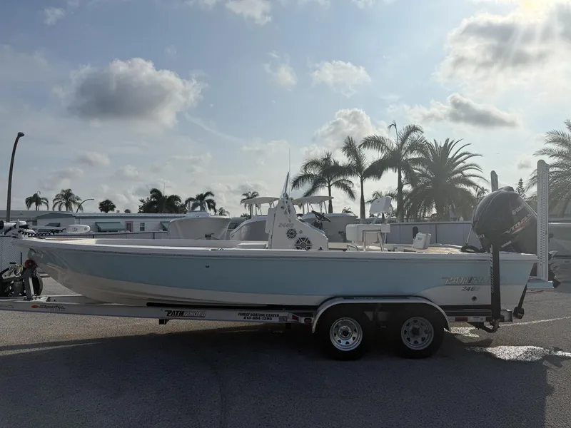 Slide: The Image of 2021 Pathfinder 2400 TRS boat on trailer, parked with palm trees in the background. - 23