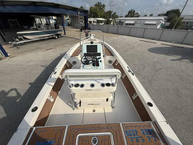 Slide: The Image of 2021 Pathfinder 2400 TRS boat with console and seating, parked outdoors. - 28