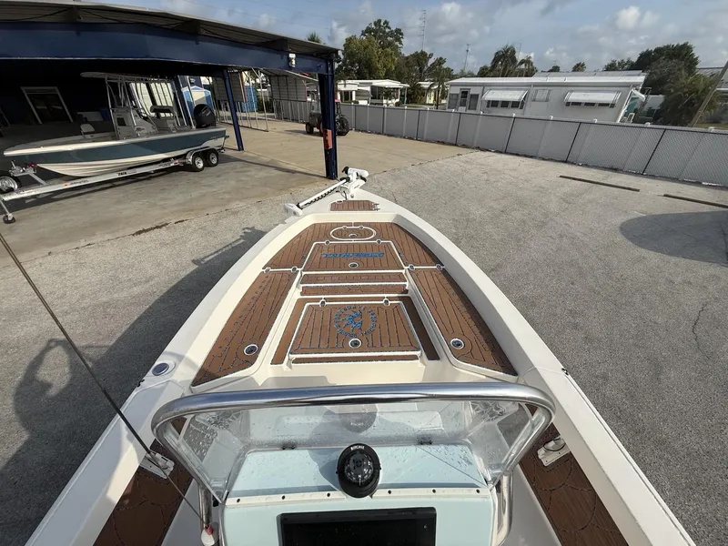 Slide: The Image of 2021 Pathfinder 2400 TRS boat with wooden deck, parked at a marina. - 29