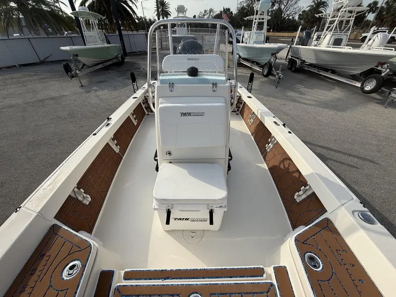 Slide: The Image of 2021 Pathfinder 2400 TRS boat interior with seating and console, parked on a lot. - 31