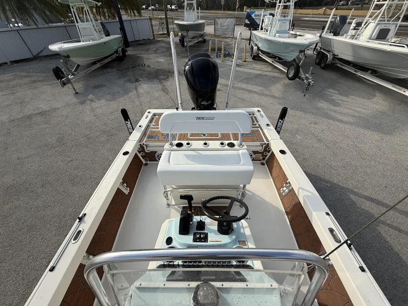 Slide: The Image of 2021 Pathfinder 2400 TRS boat interior with steering console, parked among other boats. - 32
