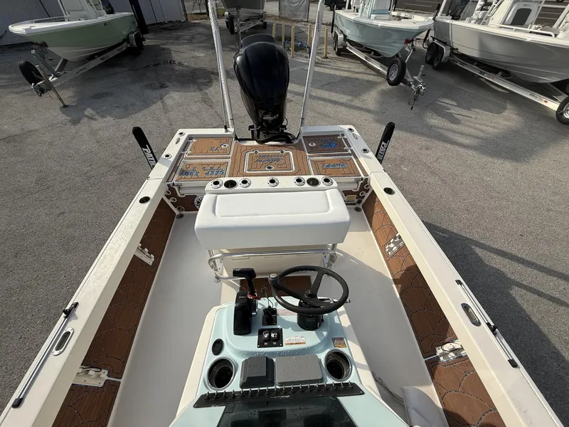 Slide: The Image of 2021 Pathfinder 2400 TRS boat interior with steering console and seating, parked on a trailer. - 33