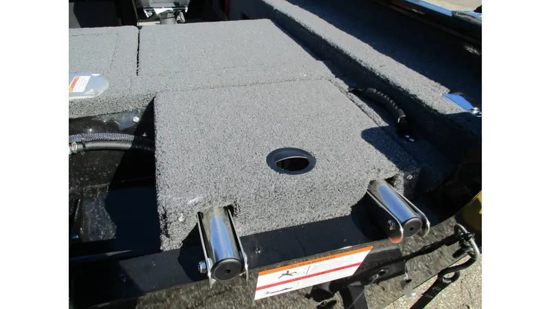 Slide: The Image of 2025 Lund Adventure 1775 Sport boat interior with gray carpeted deck and storage compartments. - 5