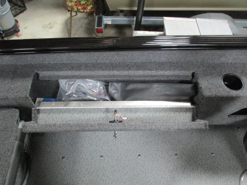 Slide: The Image of Interior storage compartment of 2025 Lund 1775 Adventure SS boat, featuring carpeted finish. - 10