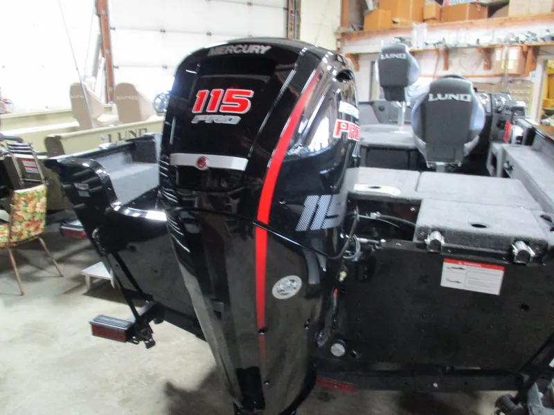Slide: The Image of 2025 Lund 1775 Adventure SS boat with Mercury 115 Pro outboard motor in a garage. - 6