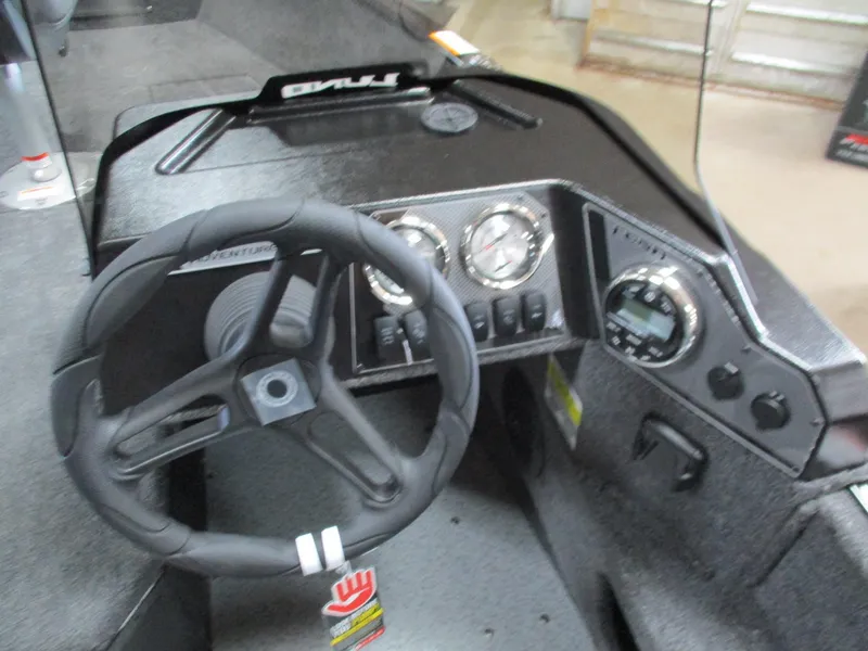 Slide: The Image of 2025 Lund 1775 Adventure SS boat dashboard with steering wheel and gauges. - 7