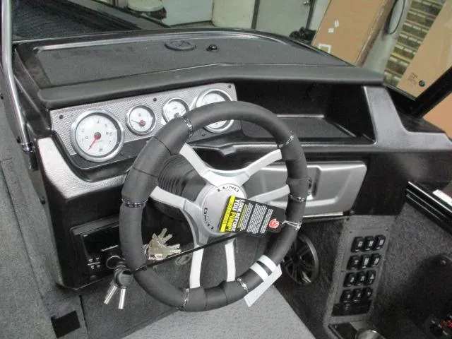 Slide: The Image of Interior dashboard of 2025 Lund 1975 Pro V Sport boat with steering wheel and gauges. - 2
