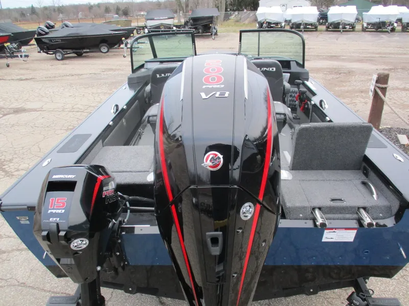 Slide: The Image of 2025 Lund 1975 Pro V Sport boat with powerful Mercury outboard engines, parked outdoors. - 27