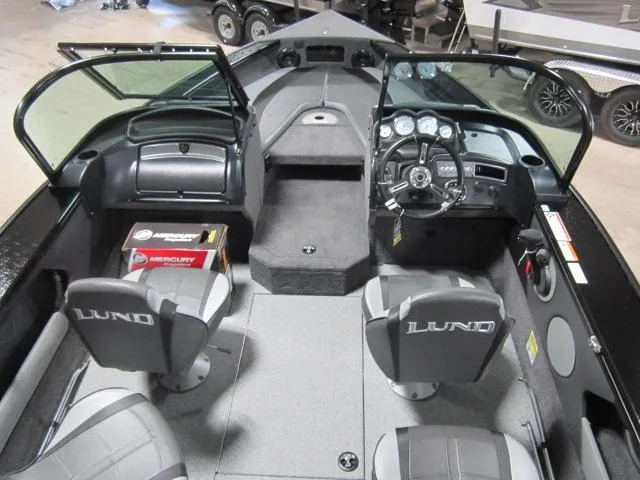 Slide: The Image of 2025 Lund 1875 Crossover XS boat interior with steering console and seating. - 13