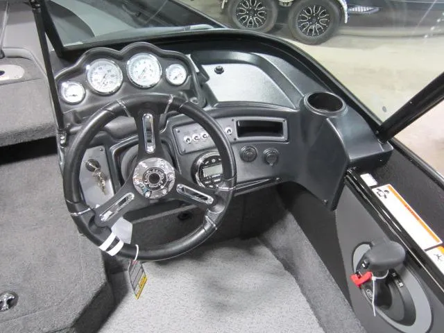 Slide: The Image of 2025 Lund 1875 Crossover XS boat dashboard with steering wheel and gauges. - 6