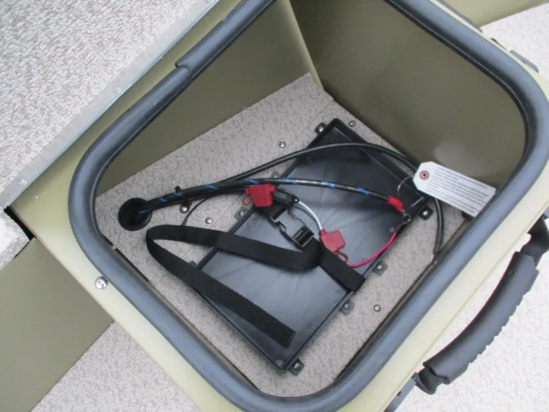 Slide: The Image of Battery compartment of 2025 Lund Alaskan 1875 Tiller boat, featuring wiring and secure straps. - 16