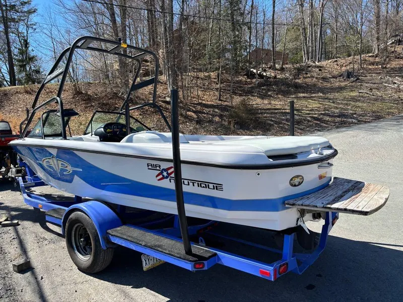 Slide: The Image of 2000 Nautique Air Nautique boat on trailer, parked outdoors in wooded area. - 13