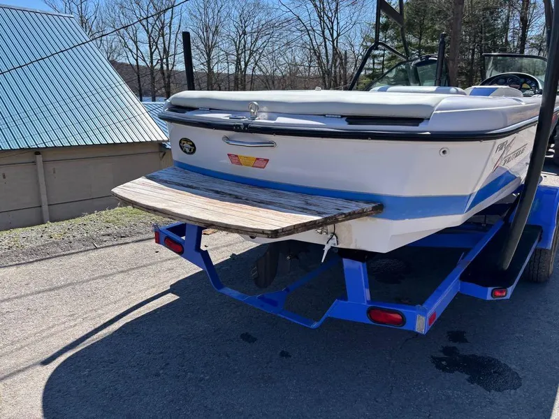 Slide: The Image of 2000 Nautique Air Nautique boat on blue trailer, parked outdoors. - 19
