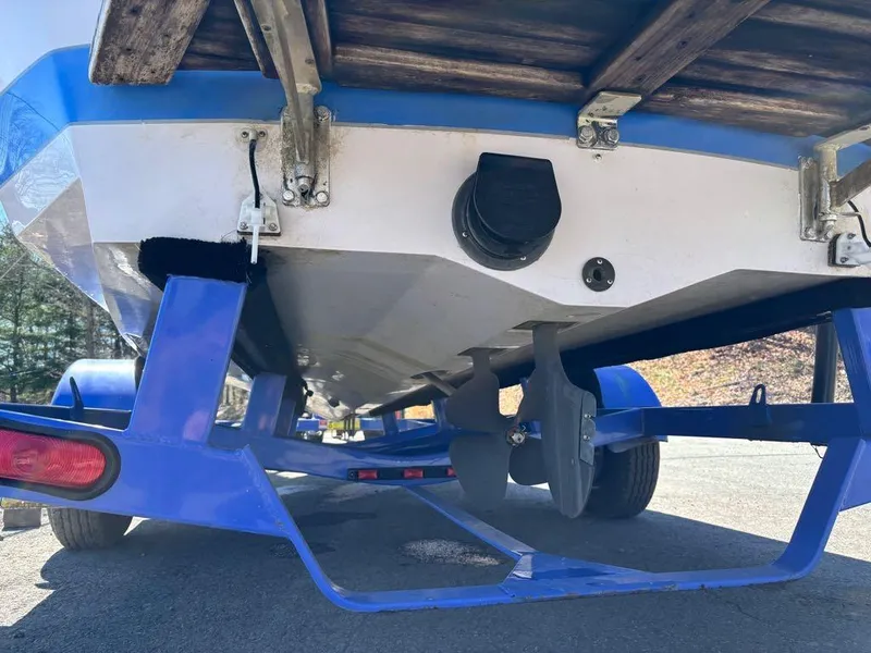 Slide: The Image of 2000 Nautique Air Nautique boat on blue trailer, showing underside and propeller. - 21